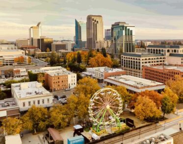 Aerial view of downtown Sacramento with a Ferris wheel and autumn-colored trees