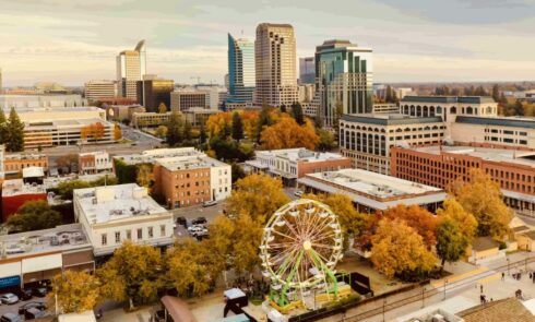 Aerial view of downtown Sacramento with a Ferris wheel and autumn-colored trees