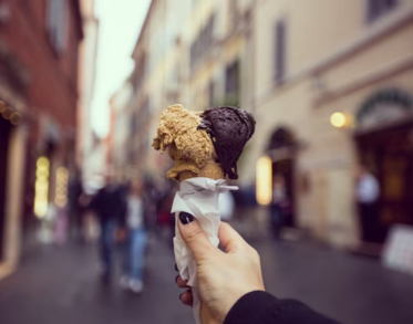 Hand holding ice cream against the background of buildings