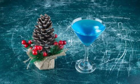 Christmas Pinecone With a Glass of Blue Cocktail