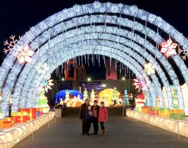 4 people take a photo under the Christmas installation