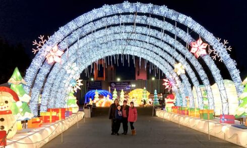 4 people take a photo under the Christmas installation
