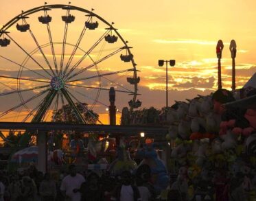 People at the fairgrounds near the Ferris wheel