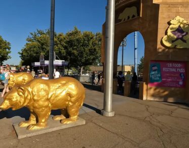 A golden bear statue greets visitors at the entrance of the fair